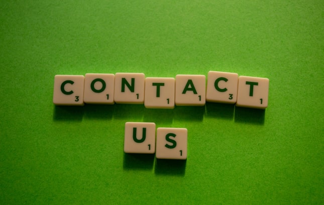 'Contact Us' spelled with scrabble tiles
